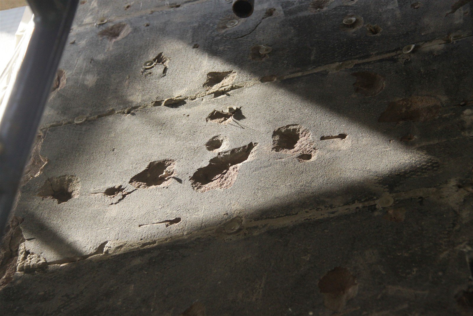 Brownstone surface pitted with spalls where lath nails had been driven in and pulled out