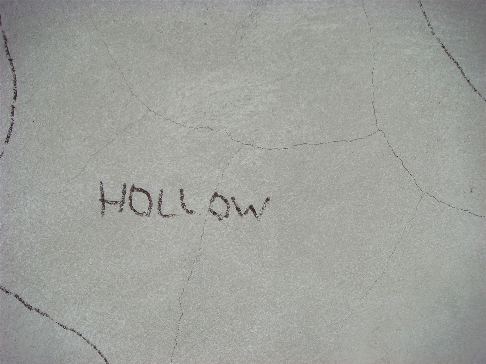 The word HOLLOW written on stucco where sounding found it had separated from the brownstone wall